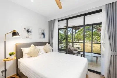 a bedroom with a white bed and a large window at Bang Tao - Laguna Beachside 3BR Apartment 130 sq m in Bang Tao Beach
