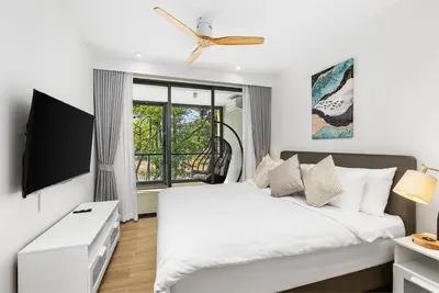 a bedroom with a white bed and a window at Bang Tao - Laguna Beachside 3BR Apartment 130 sq m in Bang Tao Beach