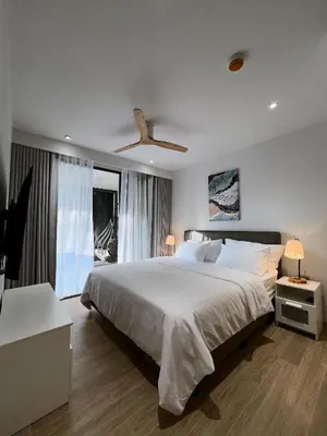 a bedroom with a large bed and a ceiling fan at Bang Tao - Laguna Beachside 3BR Apartment 130 sq m in Bang Tao Beach