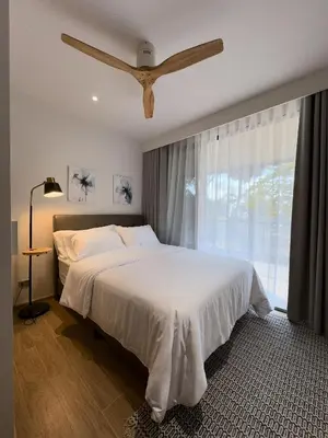 a bedroom with a bed and a large window at Bang Tao - Laguna Beachside 3BR Apartment 130 sq m in Bang Tao Beach