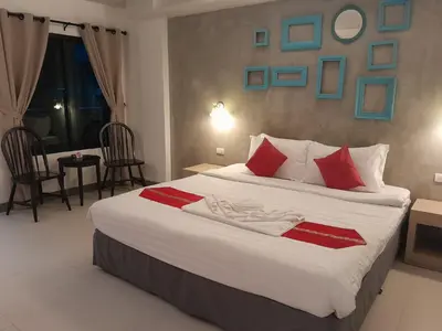 a bedroom with a large white bed with red pillows at Acca Patong Residence in Patong Beach