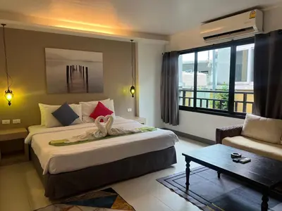 a bedroom with a bed and a couch and a table at Acca Patong Residence in Patong Beach