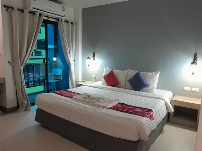 a bedroom with a large white bed with a window at Acca Patong Residence in Patong Beach