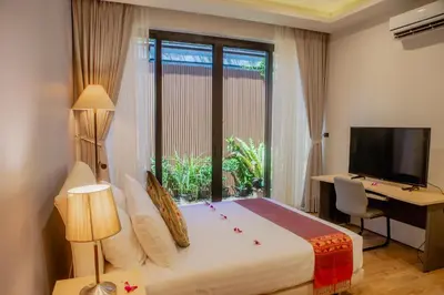 a bedroom with a bed and a desk and a television at 4BR Laguna Golf View Pool Villa Retreats Phuket in Laguna Phuket