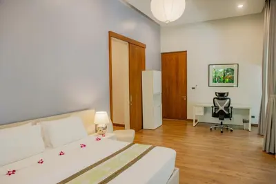 a bedroom with a bed and a desk with a chair at 4BR Laguna Golf View Pool Villa Retreats Phuket in Laguna Phuket