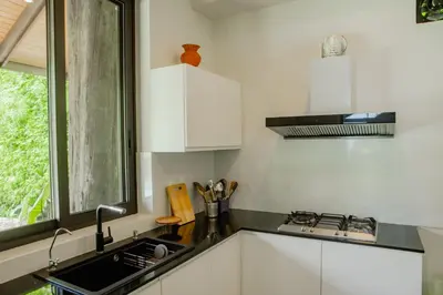 a kitchen with white cabinets and a sink and a window at 4BR Laguna Golf View Pool Villa Retreats Phuket in Laguna Phuket