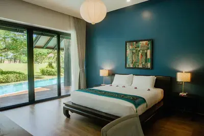 a bedroom with a large bed and a large window at 4BR Laguna Golf View Pool Villa Retreats Phuket in Laguna Phuket