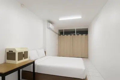 a small bedroom with a bed and a desk at Wow Boutique Patong in Patong Beach