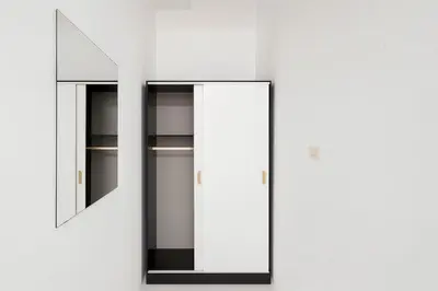 a glass cabinet with two mirrors on a white wall at Wow Boutique Patong in Patong Beach