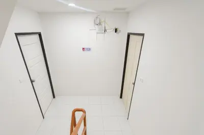 two open doors in a white room with a wooden rack at Wow Boutique Patong in Patong Beach