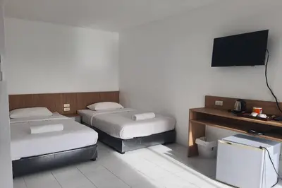 a hotel room with two beds and a television at Wow Boutique Patong in Patong Beach
