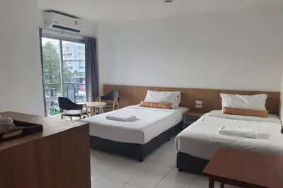a hotel room with two beds and a table at Wow Boutique Patong in Patong Beach