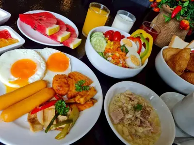 a table with plates of breakfast food on it at The Par Phuket Hotel in Kathu