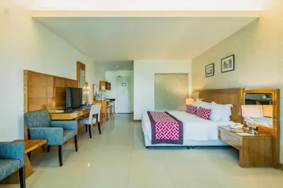 a large hotel room with a bed and a desk at The Par Phuket Hotel in Kathu