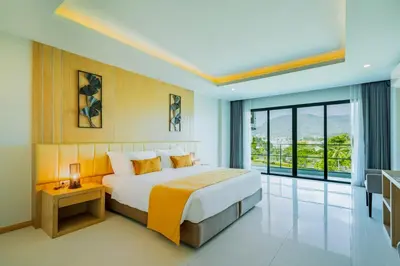 a bedroom with a large bed and a large window at The Par Phuket Hotel in Kathu