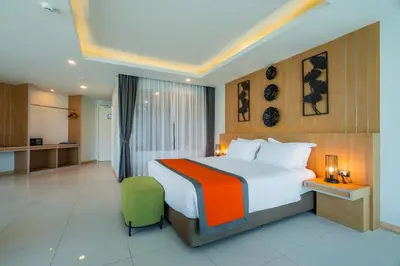 a hotel room with a bed and a kitchen at The Par Phuket Hotel in Kathu
