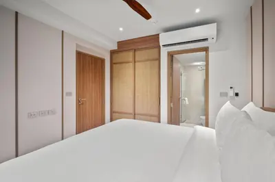 a bedroom with a large white bed and a bathroom at Laguna Beachside Block 2 by Banyan Living in Bang Tao Beach