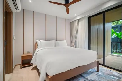 a bedroom with a white bed and a large window at Laguna Beachside Block 2 by Banyan Living in Bang Tao Beach