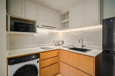a kitchen with white cabinets and a dishwasher at Laguna Beachside Block 2 by Banyan Living in Bang Tao Beach