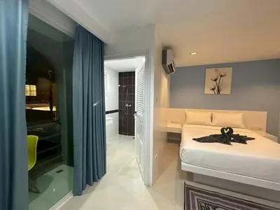 a bedroom with a bed with a pair of scissors on it at Patong gray house in Patong Beach