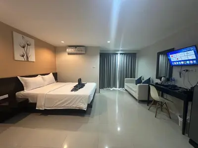 a hotel room with a bed and a television at Patong gray house in Patong Beach