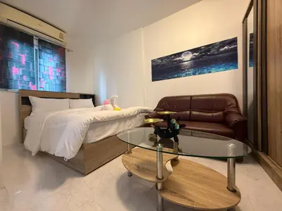 a bedroom with a bed and a glass table at Cha Cha Guesthouse in Patong Beach