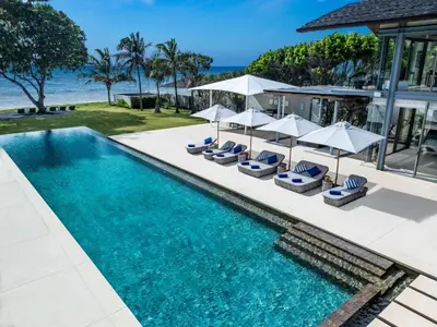 an infinity pool with chairs and umbrellas next to a house at Villa Cielo in Ban Han Pa To