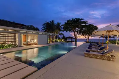an infinity pool with lounge chairs and umbrellas at Villa Cielo in Ban Han Pa To