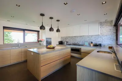 a large kitchen with wooden cabinets and a counter top at Katamanda Villa Allegra 5 bedroom Seaview villa in Ban Karon