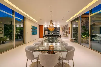 a dining room with a glass table and chairs at Villa Essenza in Ban Han Pa To
