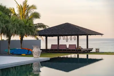 a gazebo with chairs next to a swimming pool at Villa Essenza in Ban Han Pa To