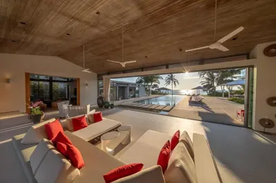 a living room with white couches and red pillows at Villa Malee Sai in Ban Han Pa To
