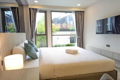 a bedroom with a white bed and a large window at 1 Bedroom 108-114 Pool View at Ozone Laguna near Bangtao Beach and Golf in Bang Tao Beach