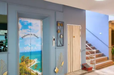 a blue wall with a door with a picture of a beach at Nora Bukit Hotel in Ban Sam Kong