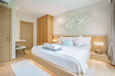 a bedroom with a large white bed and a desk at Stylish 3BR Pool Villa trichada Airport Shuttle in Phuket Town