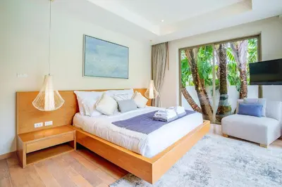 a bedroom with a bed and a chair and a window at Private 3BR Villa trichad Airport and Maid in Phuket Town