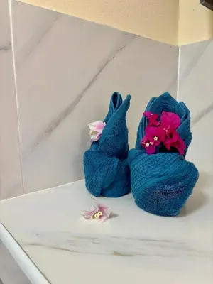 a pair of towels sitting on a counter with flowers at The glade in Ko Yao Noi
