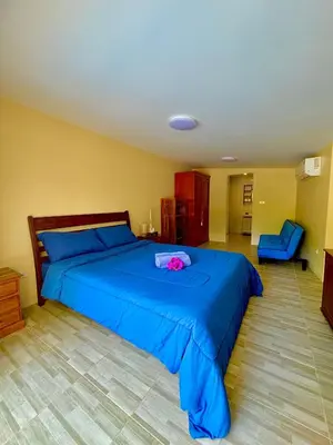 a bedroom with a blue bed with a pink flower on it at The glade in Ko Yao Noi