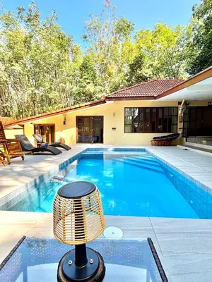 a swimming pool with a wicker fan next to a house at The glade in Ko Yao Noi