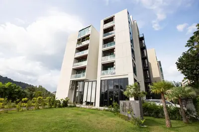 a large white building with palm trees in front of it at Seaview 1 BR Apt at VV Patong C301 near Freedom Beach in Patong Beach