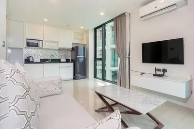 a living room with a table and a kitchen at Seaview 1 BR Apt at VV Patong C301 near Freedom Beach in Patong Beach