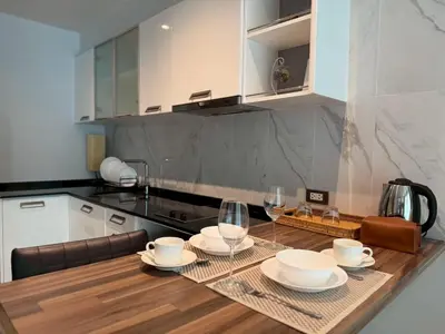 a kitchen with a table with plates and glasses at Emerald Terrace Resort 622 in Patong Beach