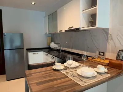a kitchen with a wooden table with two wine glasses at Emerald Terrace Resort 622 in Patong Beach