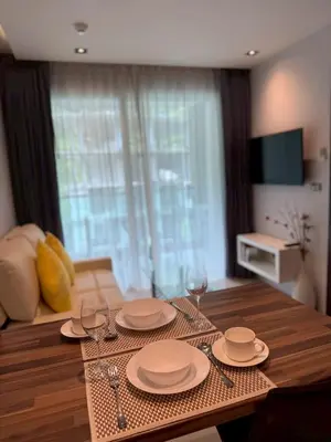 a dining room table with plates and wine glasses at Emerald Terrace Resort 622 in Patong Beach