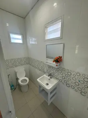 a white bathroom with a toilet and a sink at Maison Paradise Sea View in Patong Beach