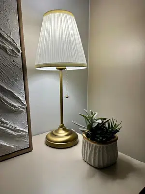a lamp sitting on a table next to a plant at Cozy apartments for a comfortable stay and accommodation in Phuket Town