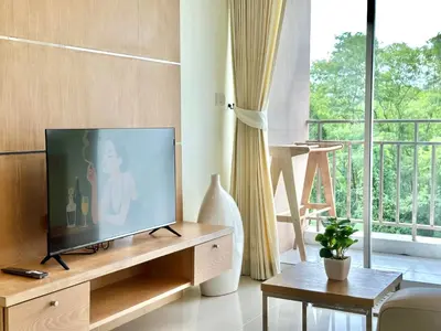 a living room with a flat screen tv on a wooden entertainment center at Pingping&FamilyAonang-2 in Ban Khlong Son