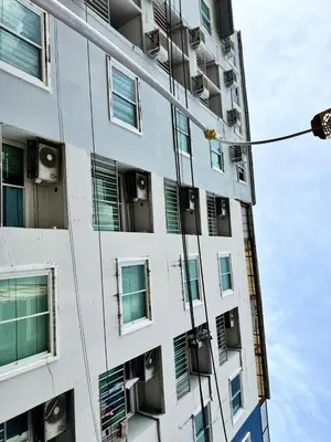 a tall apartment building with windows and air conditioners at Soul House Patong in Patong Beach