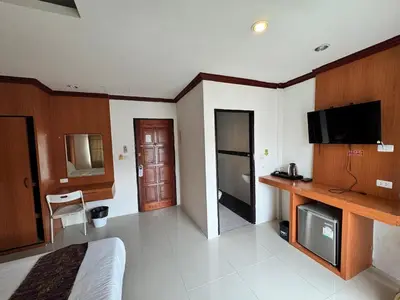 a hotel room with a bed and a tv and a room at Soul House Patong in Patong Beach