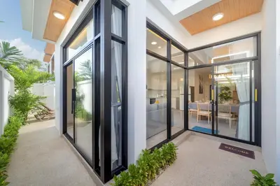 a pivot door in a house with glass windows at Villa Serana - New Private Pool Villa in Goldena Residence, Kamala in Kamala Beach